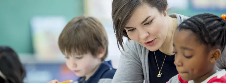 Lehrerin unterrichtet zwei Schüler:innen