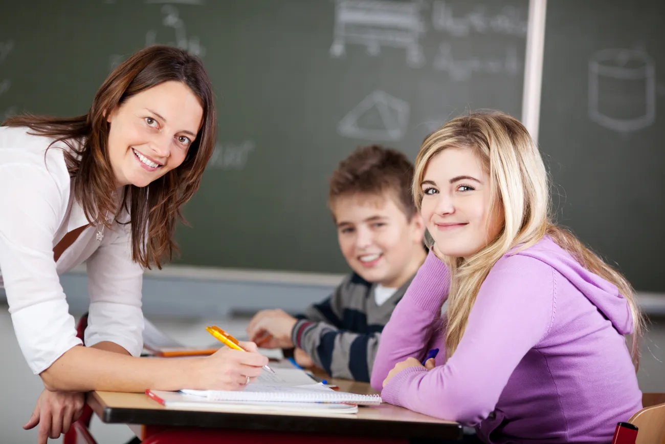Lehrerin unterrichtet zwei  Jugendliche