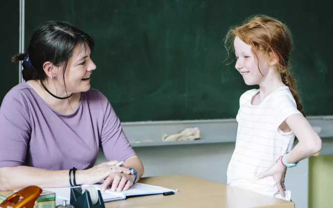 Kind fragt die Lehrerin etwas